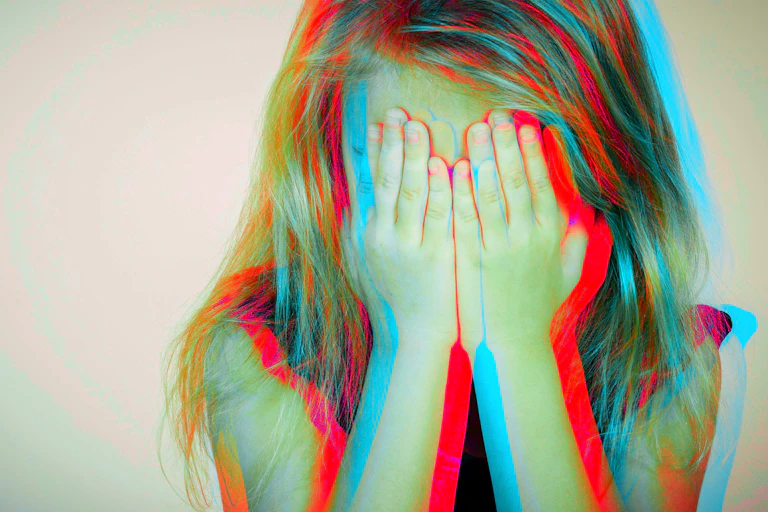 Little girl holds her face in her hands.