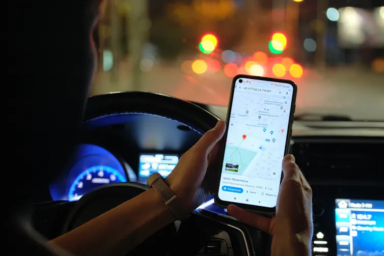 A person using a map navigation app on their phone while driving.