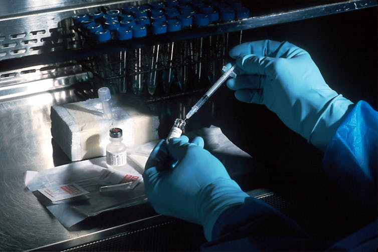 Scientist in a dark lab preparing a vaccine.