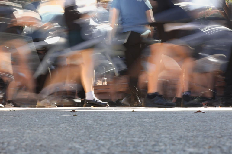 A blurred images of school children walking in a playground.
