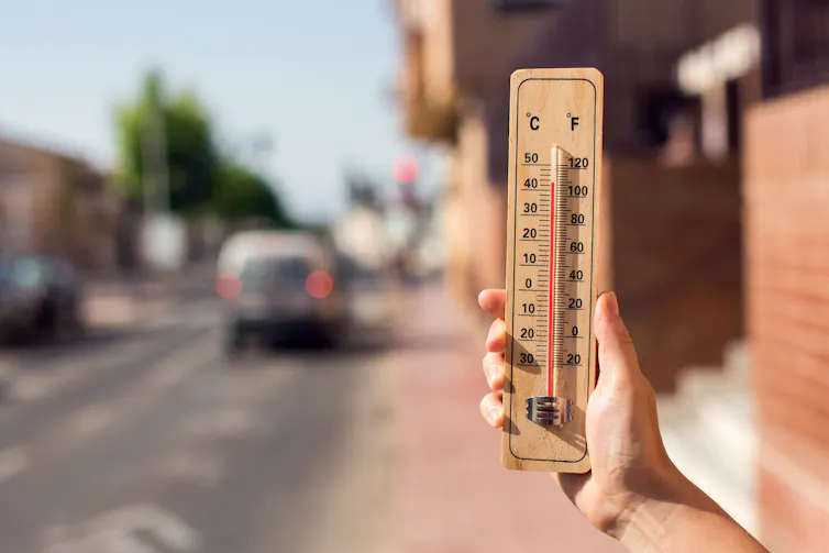 hand holding thermometer, hot day.