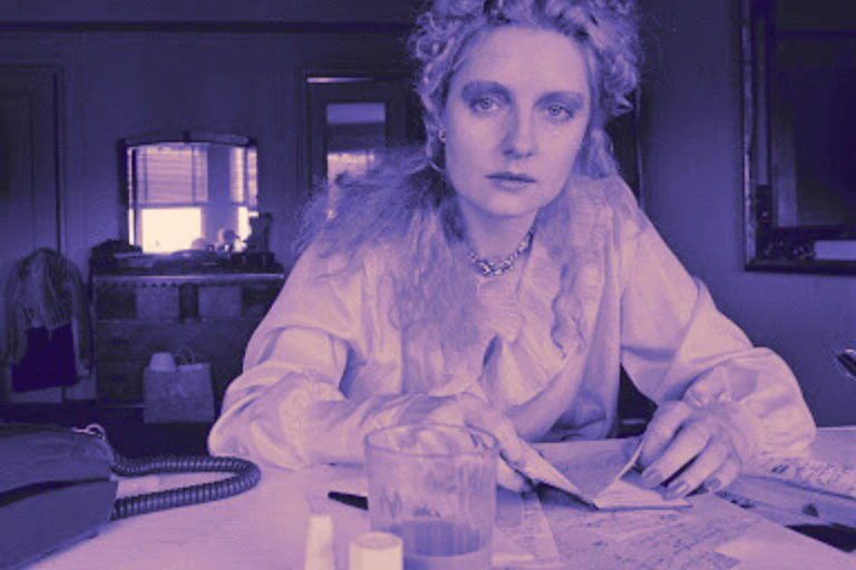 A blonde woman (Shere Hite) at her desk.