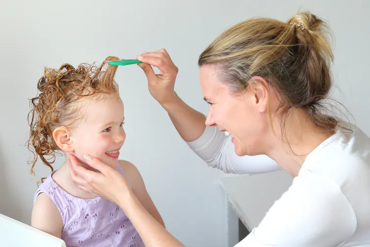 Mum combs child's hair