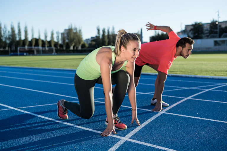 un homme et une femme sur la ligne de départ d'une course d'athlétisme