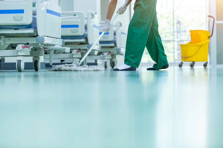 Person mopping the floor on a hospital ward.