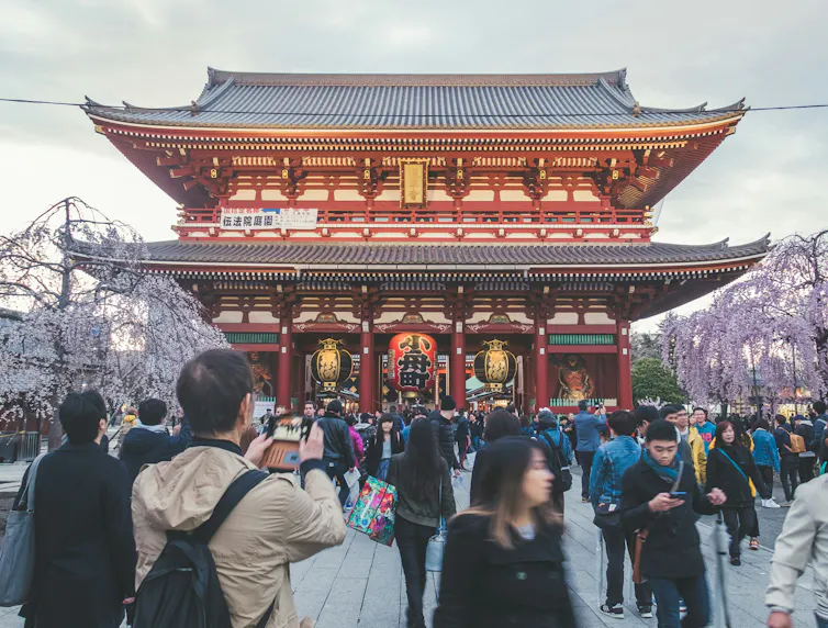 Turistas fotografían un templo en Japón.