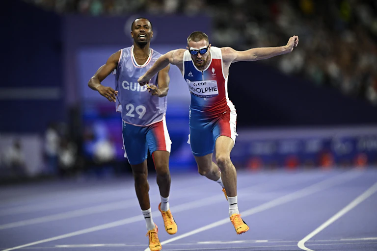 Timothée Adolphe et son guide Jeffrey Lamy participent à l'épreuve d'athlétisme du 400 m T11 masculin lors des Jeux paralympiques de Paris 2024.