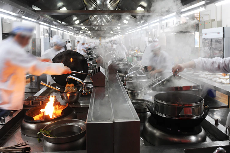 chefs working in a busy, steamy restaurant kitchen