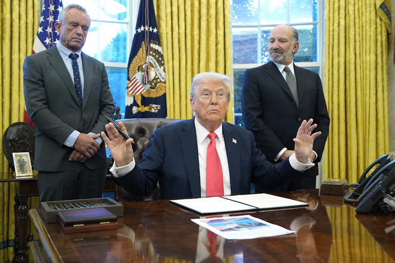 Donald Trump in the Oval Office with health secretary RFK Jnr. and commerce secretary Secretary of Commerce Howard Lutnick.