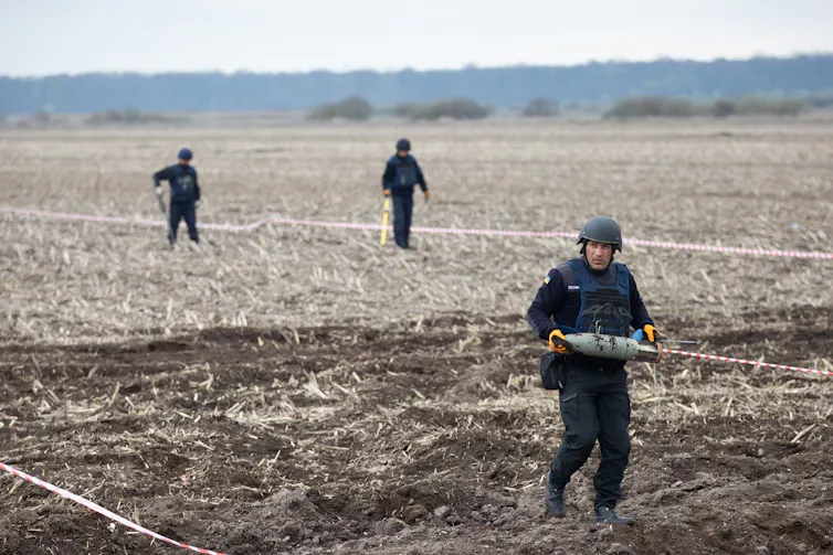 People clearing mines from a field in the Kyiv region of Ukraine.