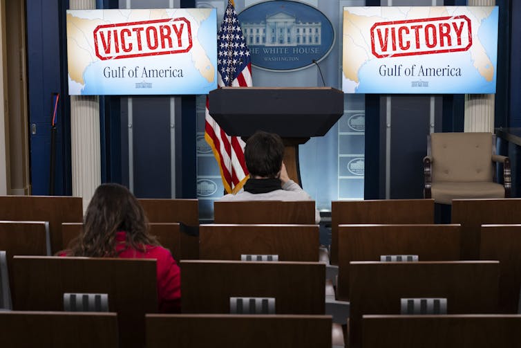 A mostly empty briefing room with Gulf of America photos reading 'Victory'
