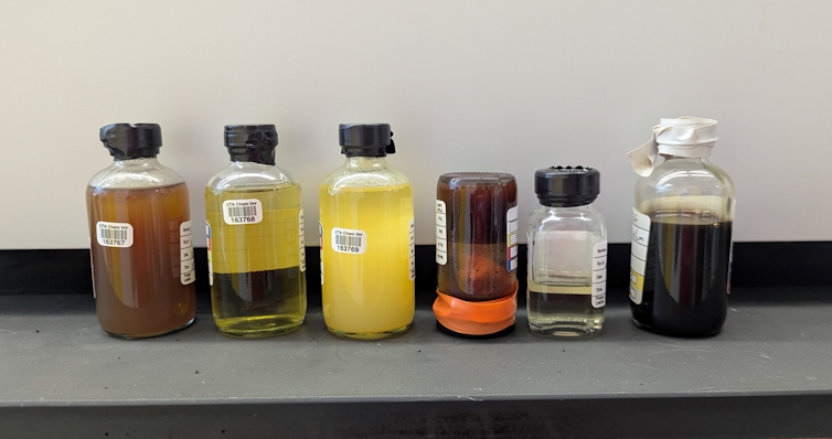 Six different vials of oil, iwth slightly different colors, clarities and thicknesses.