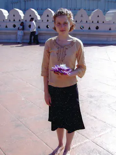 a young woman standing in front of a white wall