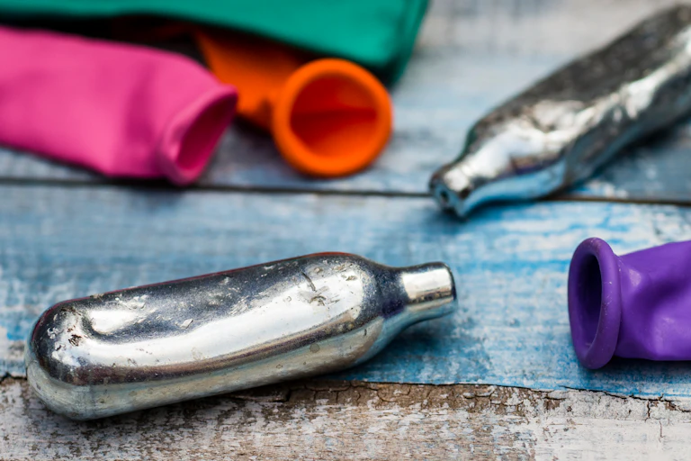 Empty silver metal canisters and balloons.