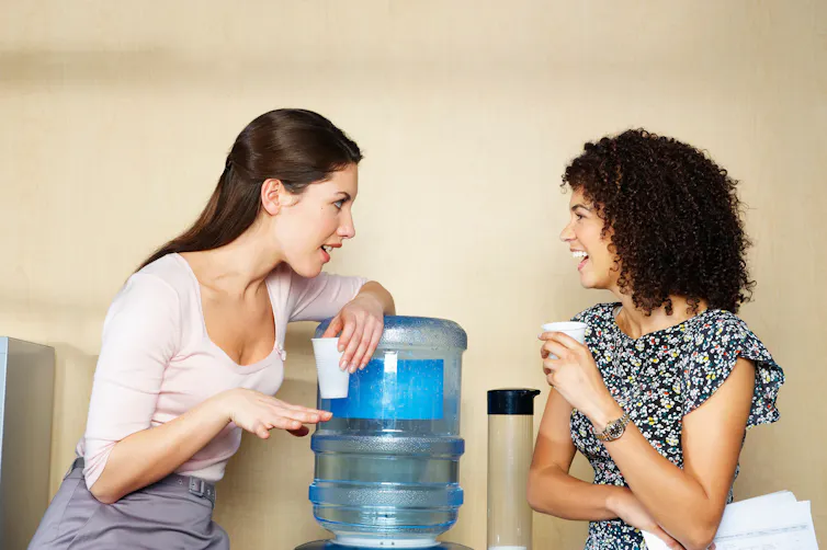 Two women are chatting by water cooler