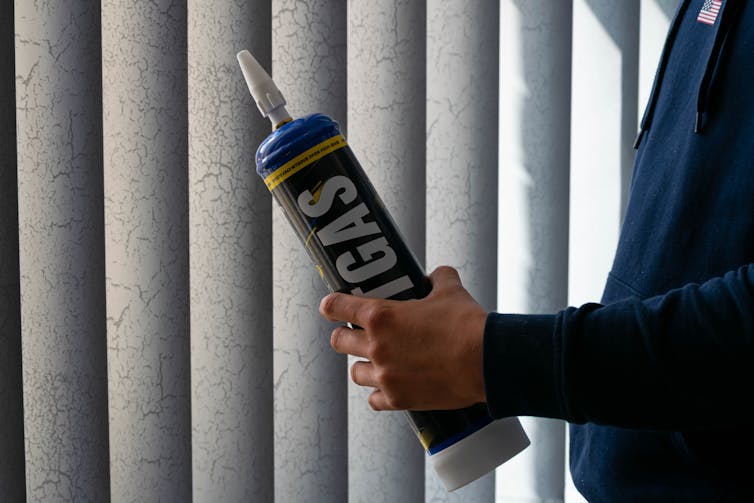 Humans hold a large laughing gas canister.