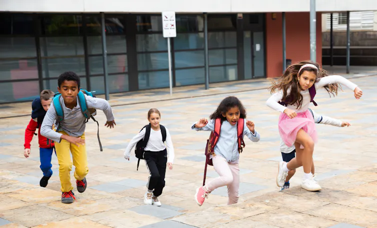 Des enfants qui courent dans une cour de récréation