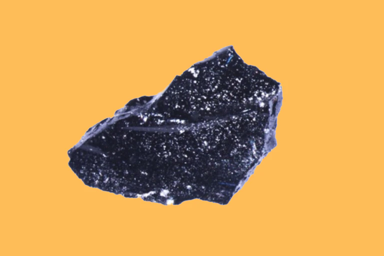 A photo of a glittering black fragment of glass.