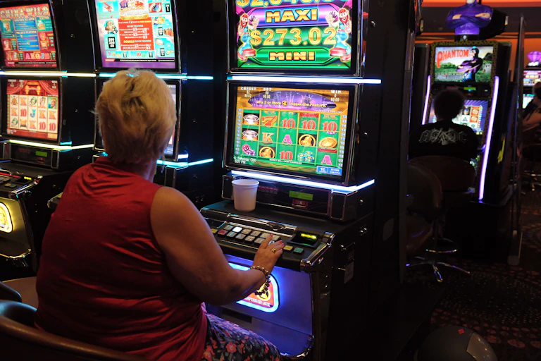 Women playing poker machine, back to camera