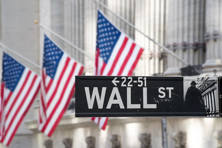 Wall St sign in front of the New York Stock Exchange building