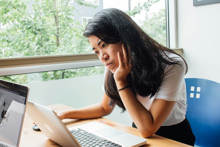 Woman working on a laptop.