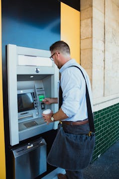 Man putting card in ATM.