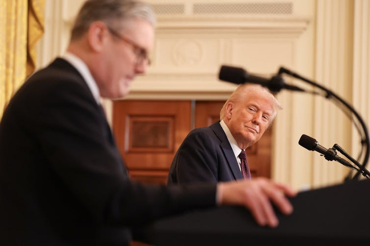 Donald Trump and Keir Starmer standing at podium.