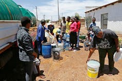 People line up with buckets at a water tanker