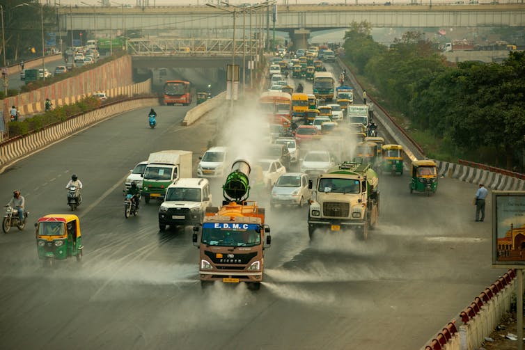 Delhi: how weather patterns and faraway mountains made this the world’s most polluted megacity 4 Truck sprays water on busy road