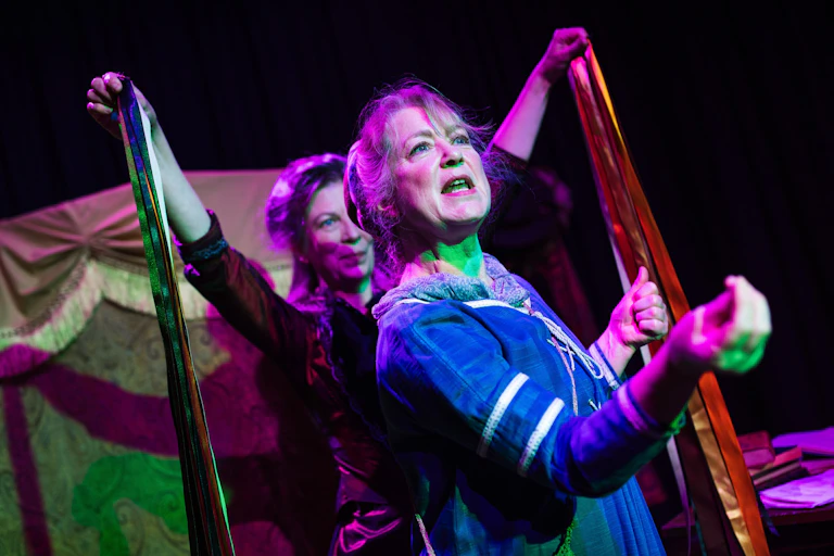 Two women on stage in Victorian clothing