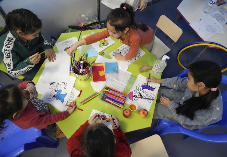 Des enfants en cercle bricolent