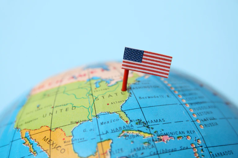 A globe has a USA flag coming out of it.