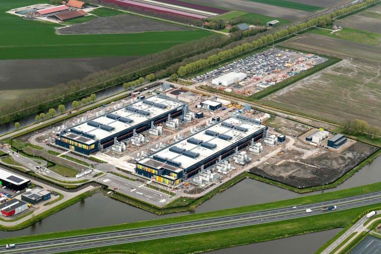 Aerial photo of a large industrial building among green fields.