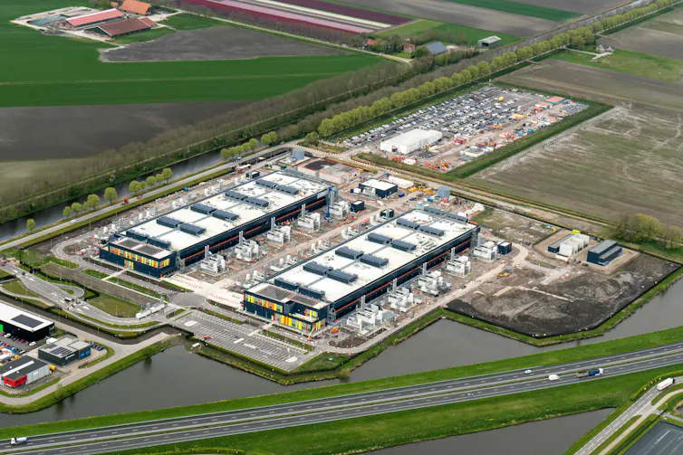Aerial photo of a large industrial building among green fields.