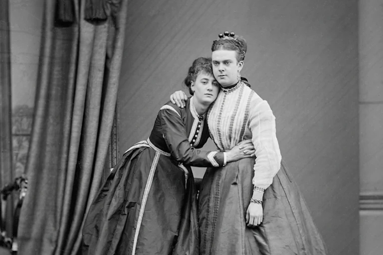 Two queer men wearing women's dresses