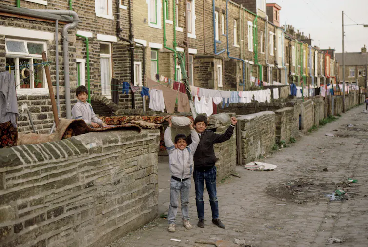 Happy children playing behind their homes in Bradford.
