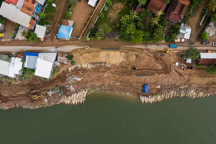 aerial shot of homes on water's edge, bare sand eroding
