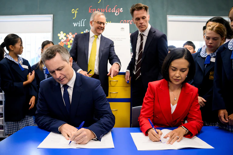 Education Minister Jason Clare and his NSW state counterpart Prue Car sign a school funding agreement.