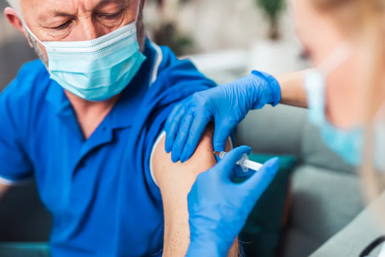 A senior man receiving a vaccination.