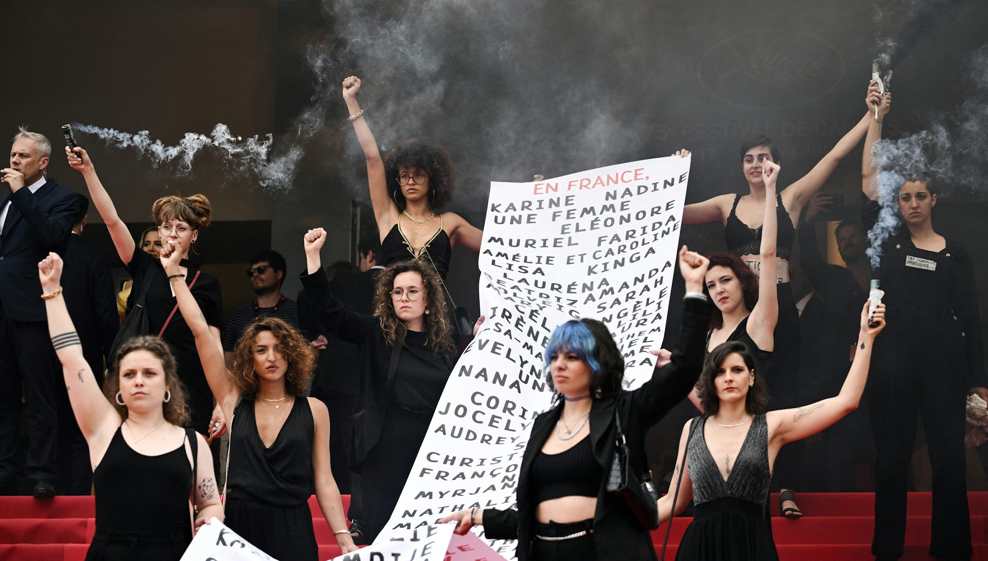 au Festival de Cannes en 2022, des membres du mouvement féministe « Les Colleuses » tiennent une banderole portant les noms de 129 victimes de féminicides.