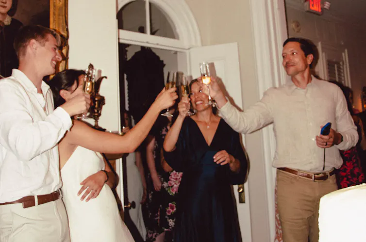 bride and groom cheers their glasses with guests