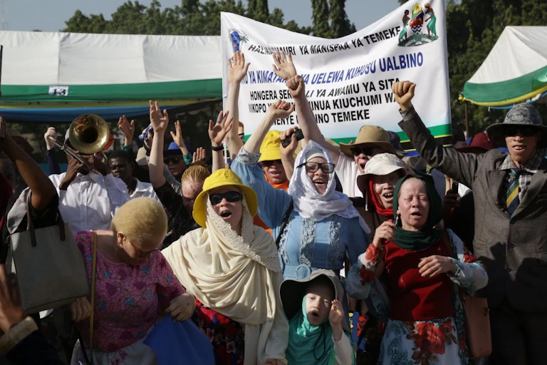 Men, women and children raising their arms while singing