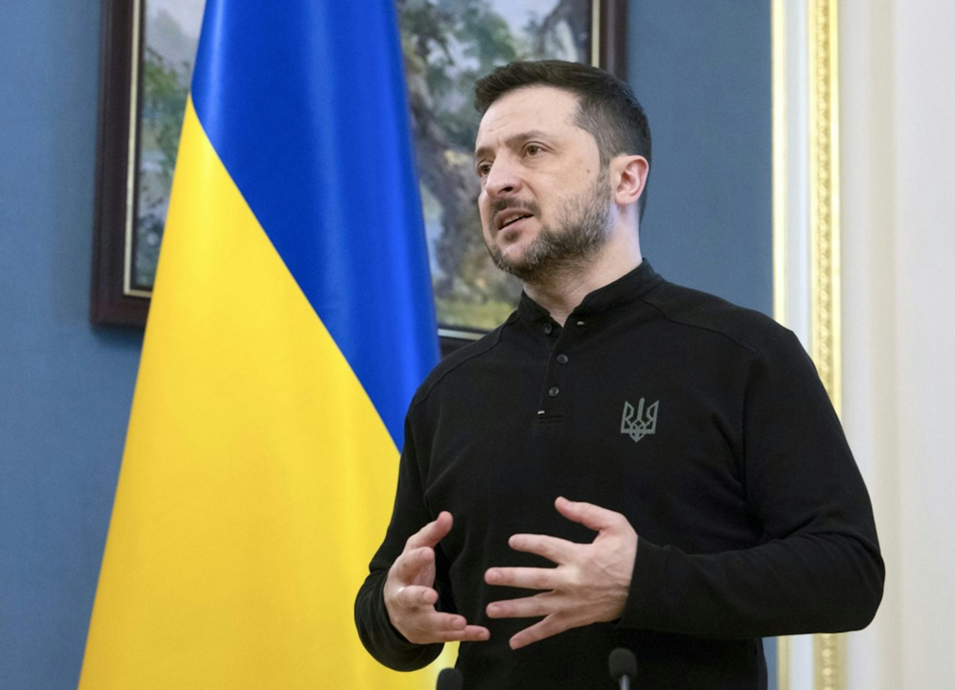 President Zelensky in front of a Ukraine flag.