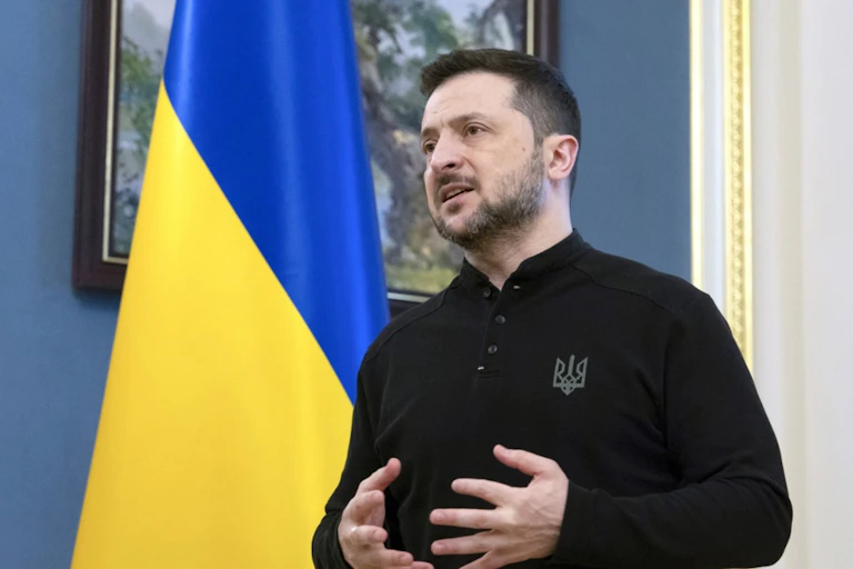President Zelensky in front of a Ukraine flag.