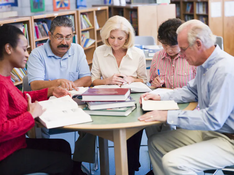 A group of older adults studying in a classroom.