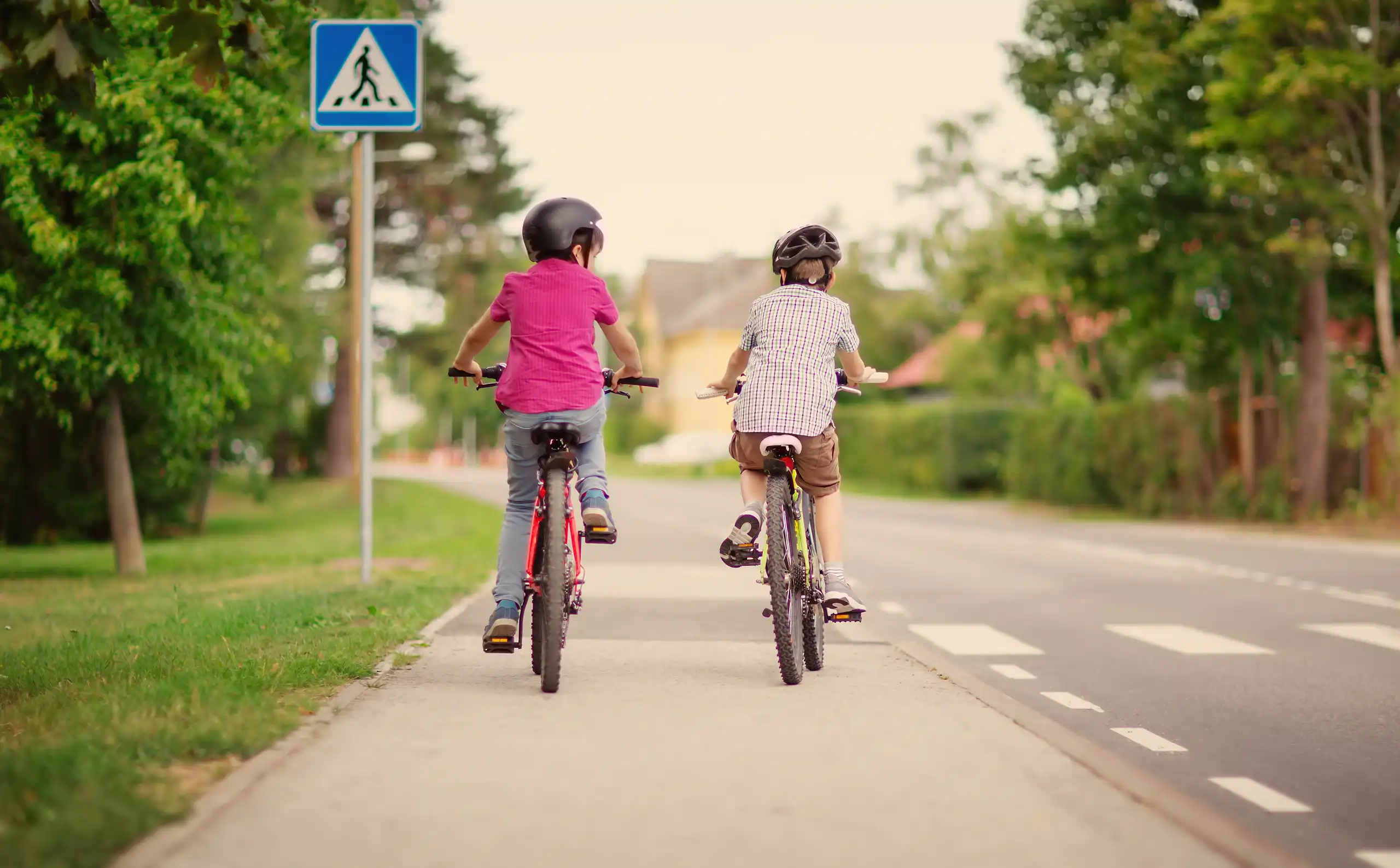 deux enfants de dos font du vélo en ville