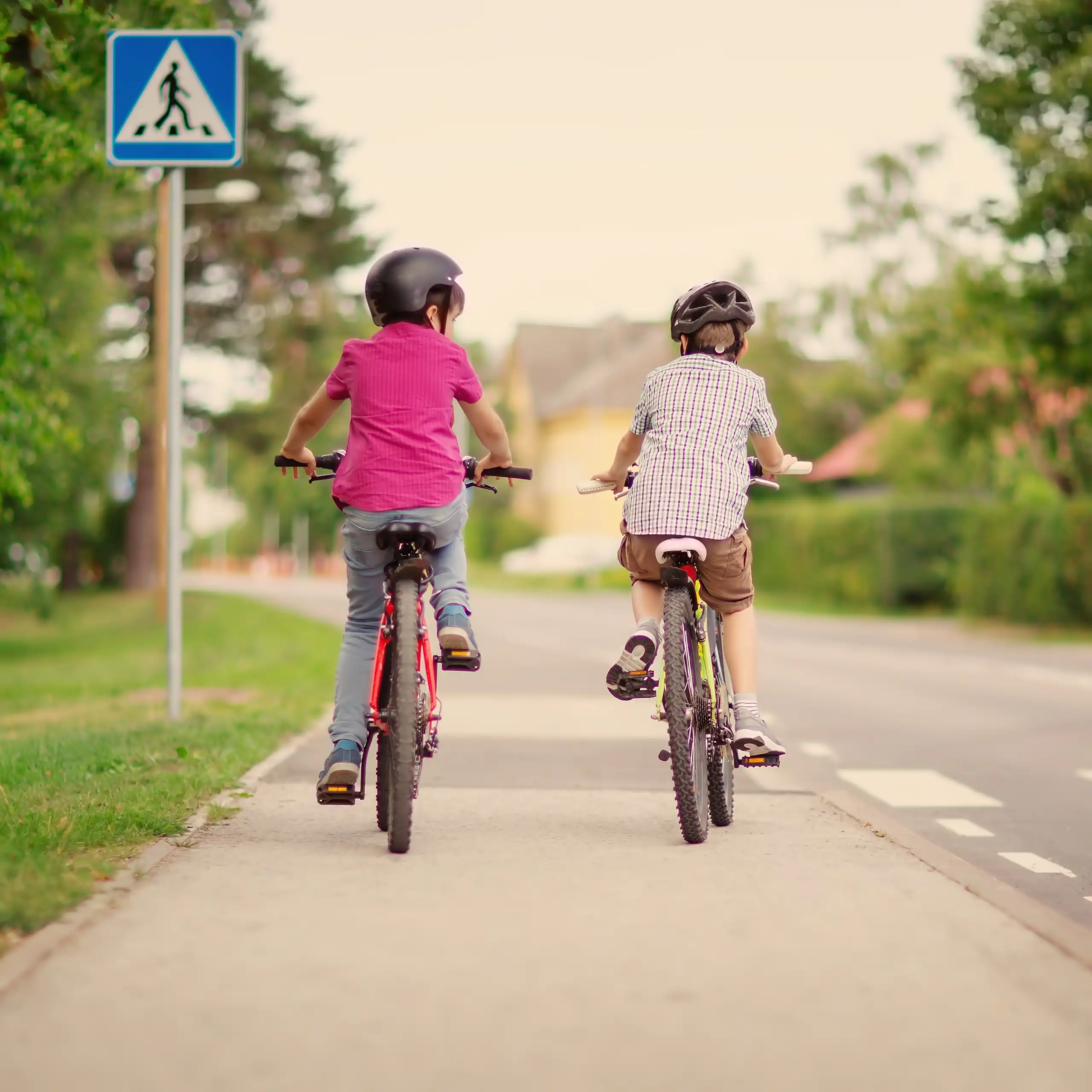 deux enfants de dos font du vélo en ville