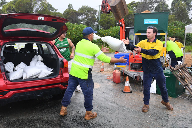 council workers help residents prepare with sandbags.