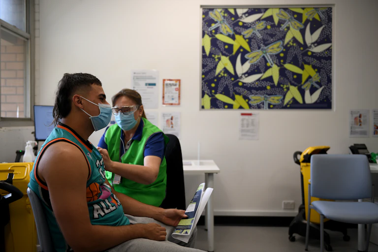 A young man receives a COVID vaccine.