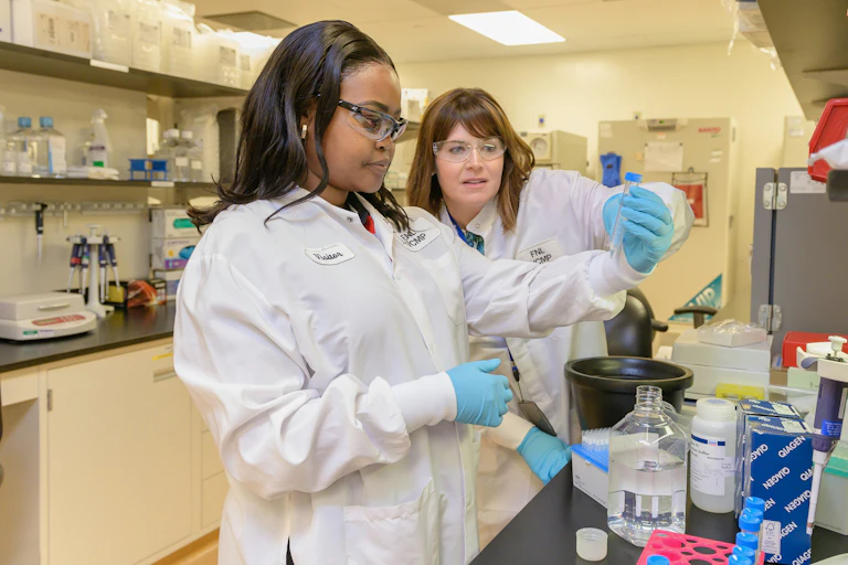 Une jeune fille et une femme travaillent dans un laboratoire.